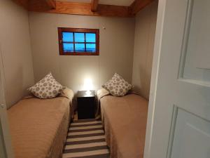 two beds in a small room with a window at Koskenselän Lomakylä in Puumala