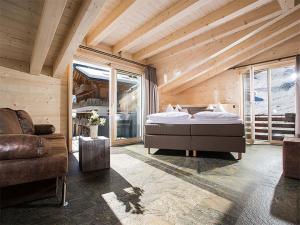ein Schlafzimmer mit einem Bett und einem Sofa in einem Zimmer in der Unterkunft Hotel Silberhorn in Lauterbrunnen