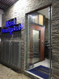 a lobby with a glass door and a brick wall at Hotel Hormiga Real in Valle del Guamuez