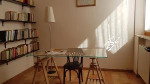 a glass table and chairs in a room with bookshelves at 41 Via Castello Farneto in Montecchio