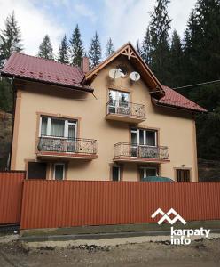 une maison avec une clôture devant elle dans l'établissement Садиба Срібні Карпати, à Yablunytsya