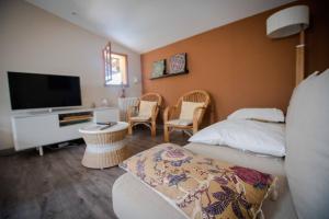 ein Hotelzimmer mit einem Bett und einem TV in der Unterkunft Gîte entre Bordeaux et Saint-Emilion in Génissac
