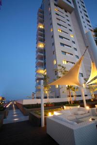 un edificio con mesa y sillas frente a un edificio en Olympic Residence Deluxe Apartments, en Limassol