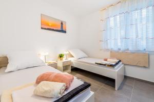 ein weißes Schlafzimmer mit einem Bett und einer Couch in der Unterkunft Apartment Lana in Baška