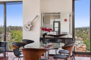 a dining room with a glass table and chairs at Ivanhoe Gem - Walk to Shops, Station & Great Views in Melbourne
