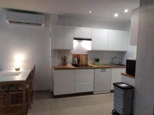 a small kitchen with white cabinets and a table at Borówka w Blue Mare in Łukęcin