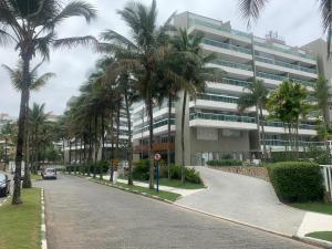 a palm tree lined street in front of a building at Apartamento em Resort Ilha da Madeira na Riviera in Riviera de São Lourenço