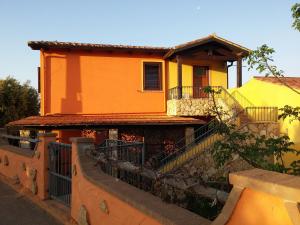 uma casa laranja com uma cerca em frente em Il Fenicottero 2 em Masainas