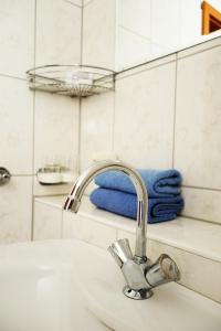 a bathroom sink with a faucet and blue towels at Aparthotel Messe Flughafen in Düsseldorf +10 photos