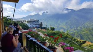 a group of people sitting on a balcony looking at the mountains at Muong Hoa View Hotel in Sa Pa