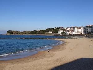 a person walking on a beach near the water at Labechiloa plage - T4 - 84 m2 - 3 ch - Centre historique in Saint-Jean-de-Luz