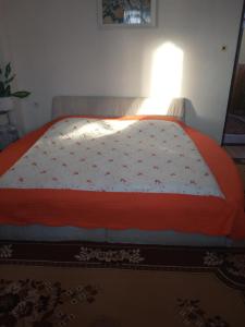 1 cama con edredón rojo y blanco en un dormitorio en Privát u Ivana, en Štrba
