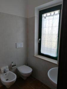 Passo CoreseにあるLe Vecchie Scuderieのバスルーム(トイレ、洗面台付)、窓が備わります。