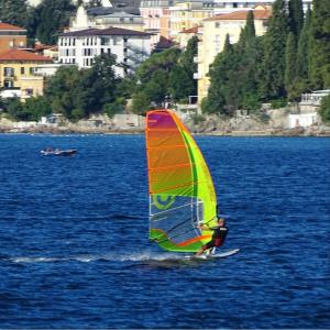 a man riding a wind sail on a body of water at Apartment Lauro Opatija, ground floor, parking, near sea in Opatija