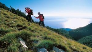 two people walking up a hill with backpacks at Apartment Lauro Opatija, ground floor, parking, near sea in Opatija