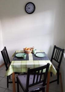 een tafel met stoelen en een klok aan de muur bij Ferienwohnung Hartmann in Papstdorf