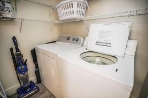 een wasmachine en droger in een kleine wasruimte bij Summerlin Condominiums by Panhandle Getaways in Fort Walton Beach