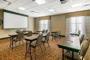 a conference room with tables and chairs and a white screen at Sleep Inn & Suites Columbia in Columbia