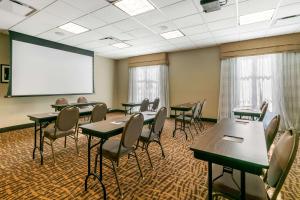 a conference room with tables and chairs and a white screen at Sleep Inn & Suites in Columbia