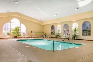 een zwembad in een grote kamer met ramen bij Quality Inn near Monument Health Rapid City Hospital in Rapid City