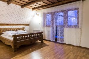um quarto com uma cama de madeira e uma janela em Apartament Bajkowy & Dwupoziomowy Krzesany em Zakopane