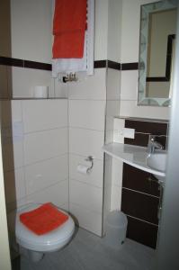 a bathroom with a toilet and a sink and a red towel at Hotel Gaum in Biberach-Ummendorf
