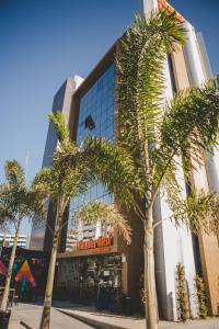 a building with palm trees in front of it at Wanderlust Hostel in Maceió