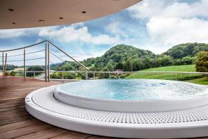 une grande piscine sur une terrasse en bois avec un pont dans l'établissement Mond, Resort & Entertainment, à Šentilj