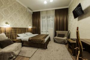 a hotel room with a bed and a chair at Petrovsky Hotel in Kamensk-Shakhtinskiy