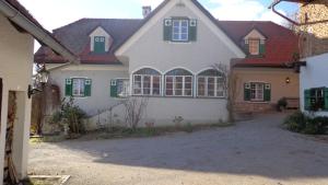 a large white house with green shuttered windows at Hirschenhof in Graz +12 photos