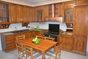 a kitchen with wooden cabinets and a wooden table at Antica Casa Cavaliere in Tramonti +6 photos