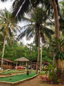 a park with palm trees and a playground at Bamboo Bungalow Baan Tai Phangan in Ban Tai