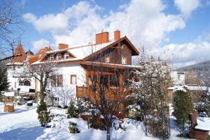 a large house in the snow with snow at Pensjonat Merkury in Świeradów-Zdrój