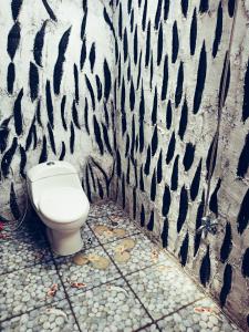 a bathroom with a toilet in front of a wall at Tereng Wilis Jungle Inn in Tetebatu