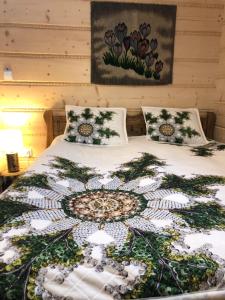 a bed with a quilt on it with two pillows at Apartamenty Willa Szafran z widokiem na góry in Zakopane