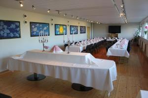 una fila de mesas en una habitación con manteles blancos en Elton Hotel, en Raufoss