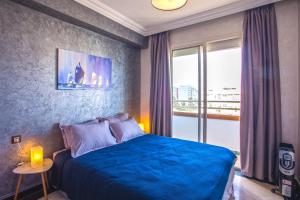 a bedroom with a blue bed and a window at Mosquee & Sea View Casablanca in Casablanca