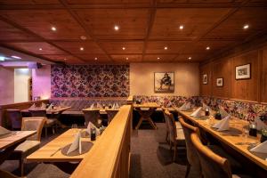 a dining room with wooden tables and chairs at Hotel Trofana Alpin in Ischgl