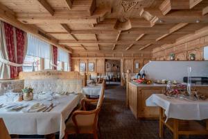 イシュグルにあるHotel Trofana Alpinの白いテーブルクロスのテーブル2台付きレストラン