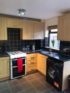 a kitchen with a stove and a washing machine at Modern two bedroom house near Jurassic Coast in Winterborne Abbas