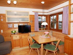 a kitchen with a table and chairs and a television at Ferienhaus Hummelbrunner in Bad Goisern