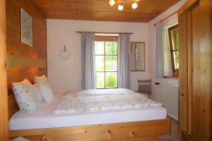 Un dormitorio con una cama grande con ventana. en Ferienhaus Hummelbrunner, en Bad Goisern 29 fotos más