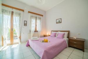 - une chambre avec un grand lit rose et un plateau de fruits dans l'établissement Family House with Garden, à Igoumenítsa