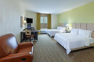 a hotel room with two beds and a couch at Candlewood Suites Houston - Spring by IHG in Houston