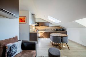 a living room with a table and a kitchen at le cocon voironnais in Rives