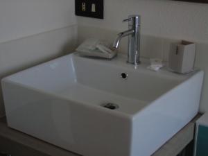 Biały zlew z kranem na górze w obiekcie B & B MARIMA ORGOSOLO w mieście Orgosolo