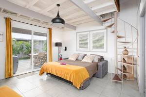 ein Schlafzimmer mit einem Bett und einem Balkon in der Unterkunft DOMAINE DE MAPOU in Les Anses-dʼArlets