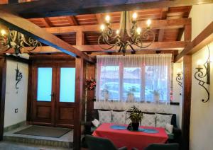 Grancharova Guest House في بانسكو: غرفة طعام مع طاولة وثريا