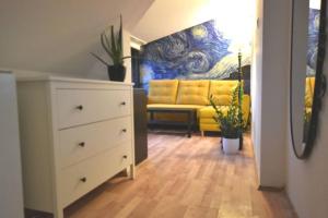 a living room with a white dresser and a yellow couch at Koci Dom in Wieliczka