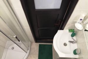 a bathroom with a white sink and a black door at Koci Dom in Wieliczka